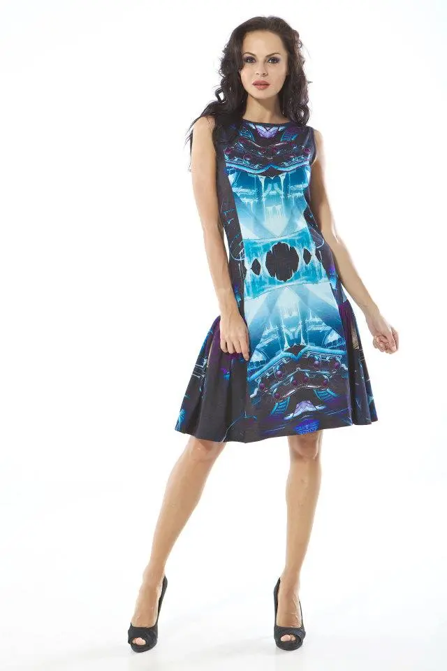 Model wearing a short silk Graphic dress gathered at the side seams from waist to knee, with a print inspired by the Batmobile in icy blue, purple, and black tones.